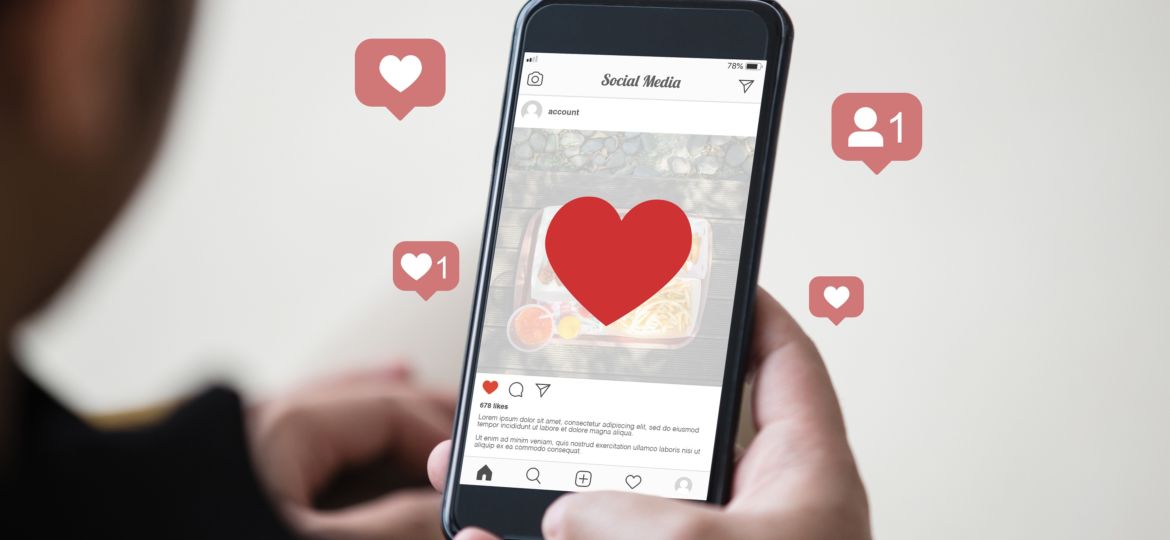 Man holding smartphone using mobile application for instagram on the screen.