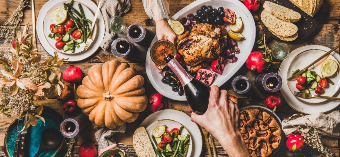 People pouring champagne and celebrating Thanksgiving day at home, top view