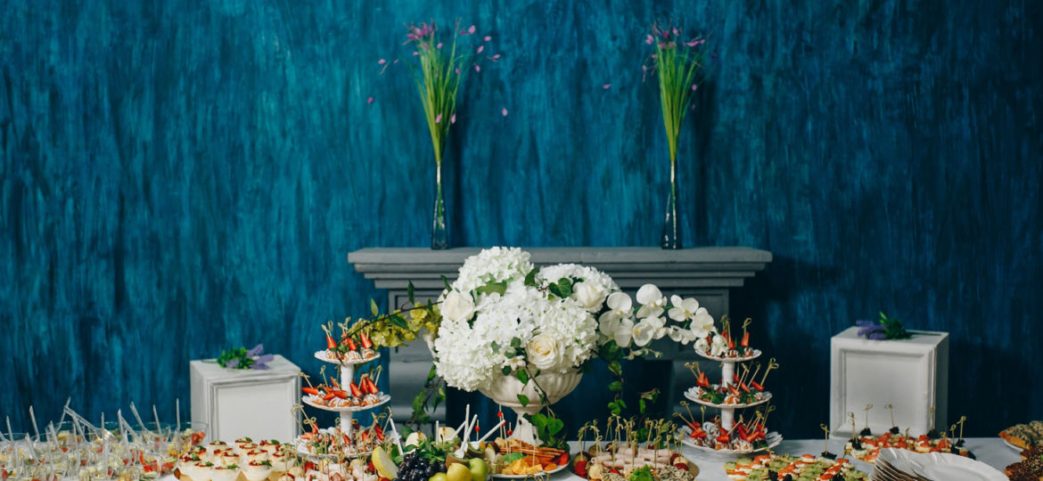 Catering table set service various snacks on a table at banquet. Set of cold snacks, canape, beverages, closeup. Side view. Banquet table